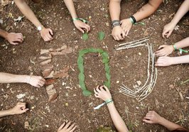Hände legen FÖJ Buchstaben auf Naturboden. Foto: Alfred Toepfer/Akademie für Naturschutz