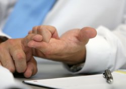 Gestikulierende Hände eines Arztes mit Zettel und Stift. Foto: Markus Lohninger/Fotolia