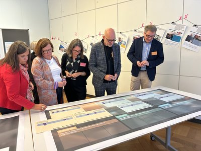 Die Mitglieder des Workshops bewerten verschiedene Themen auf einem Tisch mittels lila Chips. Foto: Stadt Oldenburg