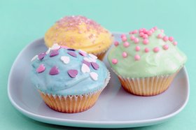 Drei bunte Cupcakes auf einem Teller. Foto: LolMicrostock/pixelio