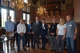 Kai Bölle, Pengfei Niu, Andreas Eißner, Yuanchao Zhao, Prof. Dr. Qinghua Zhou, OB, Tao Song, Wolfgang Pehlken, Andrea Mauritz, Uwe Brandes stehen im Großen Sitzungssaal des Alten Rathauses. Foto: Stadt Oldenburg