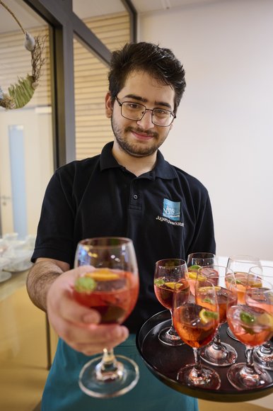 Ein Mann mit einem Tablett und Getränken. Foto: Eiko Braatz