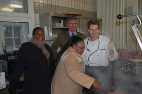 Ondela Mahlangu, Gerd Schwandner und Zukuswa Ncitha in der Küche des Internationalen Jugend Projektehauses mit einem Koch. Foto: Stadt Oldenburg