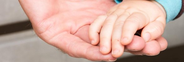 Kinderhand in einer Erwachsenenhand. Foto: Stadt Oldenburg