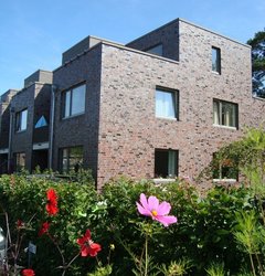 Neubau mit Blumen im Vordergrund. Foto: Stadt Oldenburg