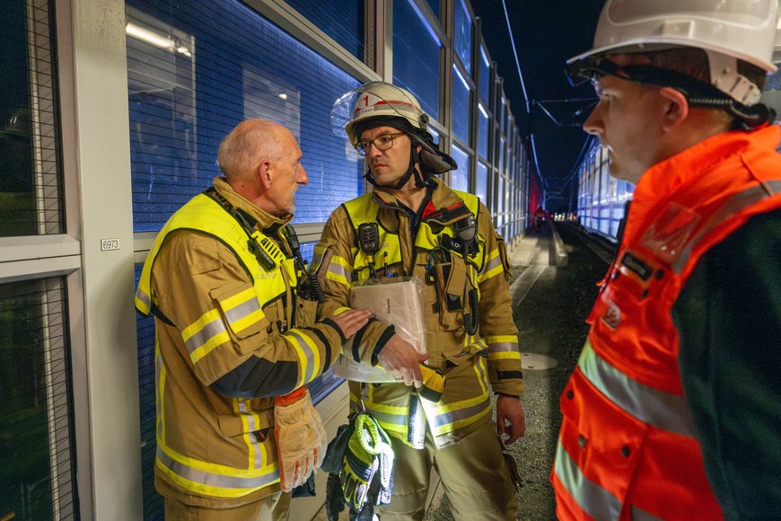 Zwei Feuerwehrleute besprechen sich und ein weiterer Mann hört zu. Foto: Sascha Stüber