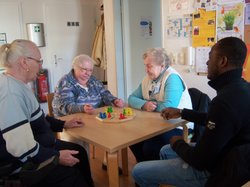 Vier Personen sitzen an einem Tisch und spielen ein Brettspiel. Foto: Stadt Oldenburg