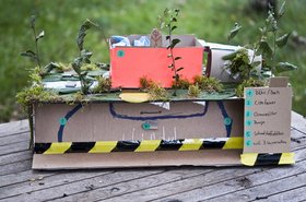 Auf dem Bild sieht man ein Modell aus Pappe bei dem ein Container als Schwimmbad benutzt wird. Foto Anschlaege Klein 