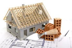 Hausmodell mit Plan, Ziegelsteinen und Kelle. Foto: Gerhard Seybert/Fotolia