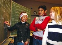 Three pupils in front of a blackboard. Picture: Koordinierungsstelle Integrationslotsen Oldenburg