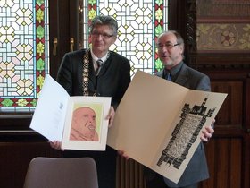 Gerd Schwandner und Derek Osbourne halten jeweils eine großformatige Grafik in der Hand. Foto: Stadt Oldenburg