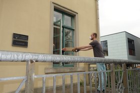 Ein Paket wird durch ein Fenster abgegeben. Foto: Stadt Oldenburg