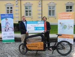 Axel Eilers, Vorstands­vorsitzender der Ammerländer Versicherung, überreicht den Scheck für das Erreichen des neunten Etappenziels an Ernst Schäfer von Rädchen für alles. Foto: Stadt Oldenburg