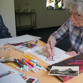Teilnehmerin eines biografischen Kunstworkshops beim Zeichnen ihrer Wohnbiografie. Foto: privat