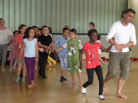 Kinder tanzen einen großen Reigen. Stadt Oldenburg