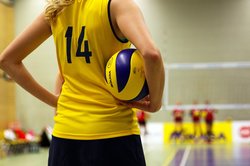 Volleyballspielerin mit einem Volleyball unterm Arm. Foto: Tania Van den Berghen/Pixabay