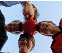 Vier Jungs halten mit ihren Köpfen einen Ball in der Mitte. Foto: S. Hofschläger/Pixelio