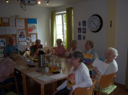 Eine Gruppe Menschen sitzen am Tisch und trainieren ihr Gedächnis.