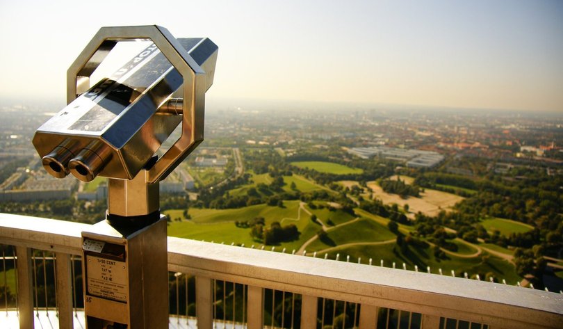 Es ist ein Fernrohr zu sehen, das auf eine grüne und besiedelte Landschaft gerichtet ist. Foto: Viktor Juncker/Pexels.de 