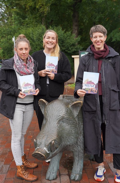 Von links: Künstlerin und Kunstvermittlerin Laura Keppel, Fotografin Carolin Werel und Sandrine Teuber von der Bildung und Vermittlung der städtischen Museen präsentieren das Stadtteilheft auf dem Marktplatz in Eversten. Foto: Stadtmuseum Oldenburg Foto: Stadtmuseum Oldenburg