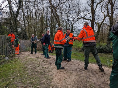Mitarbeitende des Grünflächenamtes räumen per Menschenkette Sandsäcke aus unbefahrbarem Gelände in der Nähe des Friedhofs. Foto: Stadt Oldenburg Mitarbeitende des Grünflächenamtes räumen per Menschenkette Sandsäcke aus unbefahrbarem Gelände in der Nähe des Friedhofs. Foto: Stadt Oldenburg