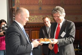 Oberbürgermeister Gerd Schwandner überreicht Ton Schroor ein Geschenk. Foto: Stadt Oldenburg