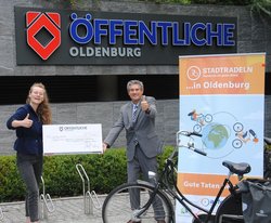 Christian Bunk, Vertriebsdirektor Öffentliche Versicherungen Oldenburg, übergibt den Scheck für das Erreichen des vierten Etappenziels an Nele Lühmann, Ehrenamtskoordinatorin von Trauerland e.V. Foto: Stadt Oldenburg