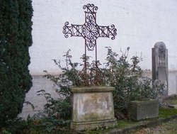 Mausoleumswand mit Kreuz und kleinem Strauch. Foto: Stadt Oldenburg