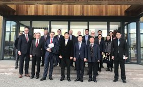 Die Oldenburger Delegation steht mit Vertreterinnen und Vertretern des Sino-German Ecopark vor einer Gebäudefassade aus Holz und Glas. Foto: Stadt Oldenburg