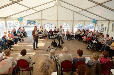 Menschen singen in einer großen Runde beim Liedernachmittag. Foto: Stadt Oldenburg