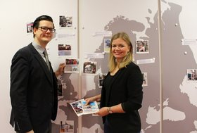 Veit Bohlen (VHS Oldenburg) und Ann-Kathrin Bromund (Stadt Oldenburg) vor der Europakarte in der VHS Oldenburg, an der schon einige Bilder hängen. Foto: Stadt Oldenburg