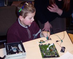 Ein Junge baut ein CD-Rom-Laufwerk auseinander. Quelle: Physik für Kids