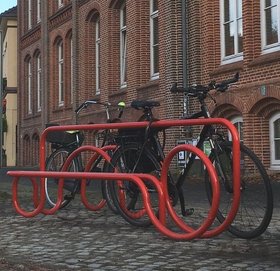 Fahrradständer Tube Line aus rot lackiertem Metall mit angeschlossenen Fahrrädern. Foto: Stadt Oldenburg