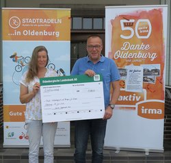 Günter Walter, Geschäftsführer der aktiv und irma Verbrauchermarkt GmbH übergibt den Scheck für das Erreichen des ersten Etappenziels an Astrid Engelhardt-Stäb, Vorständin von Harfe e.V. Foto: Stadt Oldenburg