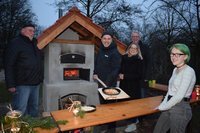 Freuten sich über die gelungene Ofen-Einweihung: (von links) Eckhardt Schwenker, Martin Haff, Alina Bremke und Christian Fritsch – eine der ersten Pizzen ließ sich Abenteuerspielplatz-Besucherin Lia schmecken. Foto: Stadt Oldenburg