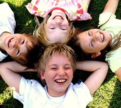 Lachende Kinder auf einer Wiese. Foto: S. Hofschlaeger/Pixelio