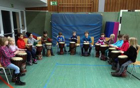 Kinder in einer Turnhalle beim Trommeln. Foto: privat