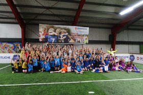 Die mehr als 100 Teilnehmerinnen sind versammelt vor einem Tor des Sportparks Donnerschwee und reißen jubelnd die Arme in die Luft. Foto: Integration durch Sport & Bildung e.V.