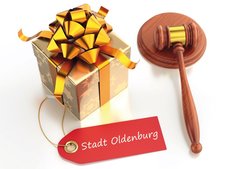 Ein Weihnachtsgeschenk liegt neben einem Auktionshammer. Foto: Sergey Tarascow/Fotolia