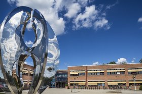 Skulptur aus spiegelndem Metall, im Hintergrund das Backsteingebäude des Rathauses von Høje-Taastrup. Foto: Claus Björn Larsen