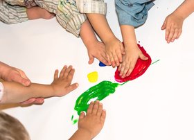 Kinderhände verschmieren bunte Farben. Foto: Stadt Oldenburg