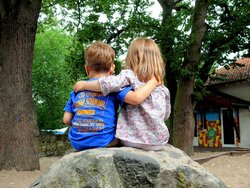 Zwei Kinder sitzen Arm in Arm auf einem Stein. Foto: S.v.Gehren/pixelio.de Zwei Kinder sitzen Arm in Arm auf einem Stein. Foto: S.v.Gehren/pixelio.de