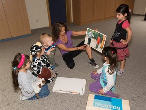 Eine Erzieherin zeigt den Kindern ein Bild. Foto: Stadt Oldenburg Eine Erzieherin zeigt den Kindern ein Bild. Foto: Stadt Oldenburg