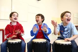 Three boys playing bongo drum and singing. Picture: Landesverband deutscher Musikschulen Niedersachsen