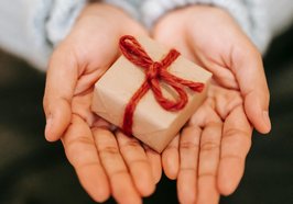 Hände halten ein kleines Geschenk. Foto: Liza Summer/Pexels