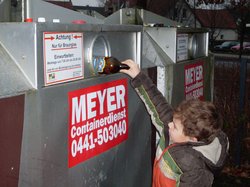 Ein Kind wirft eine Flasche in einen Altglascontainer. Foto: Stadt Oldenburg