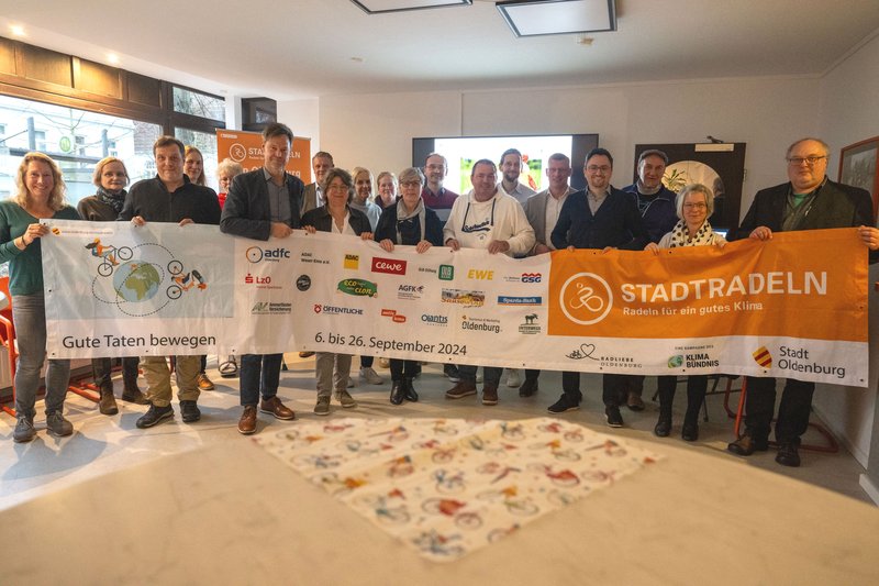 Teilnehmende der Abschlussveranstaltung von STADTRADELN 2024 halten das Banner des Wettbewerbs. Foto: Sascha Stüber