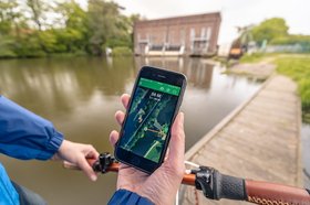 Fahrradfahrerin mit GPS Gerät beim Geocaching. Foto: Oldenburg Tourismus und Marketing GmbH/Mario Dirks