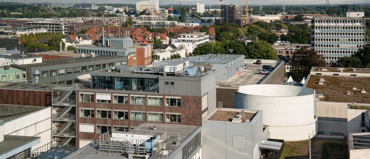 Blick vom Turm der Oldenburger Lamberti-Kirche über die Geschäfte der Innenstadt Richtung Hafen und Windräder. Foto: Mittwollen & Gradetchliev