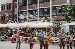 Kinder freuen sich über große Seifenblasen in der Oldenburger Innenstadt während eines Kultursommers. Foto: Mittwollen und Gradetchliev